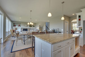 Modern kitchen with granite island and dining area.