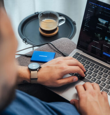 Person working on a laptop with a cup of coffee nearby.